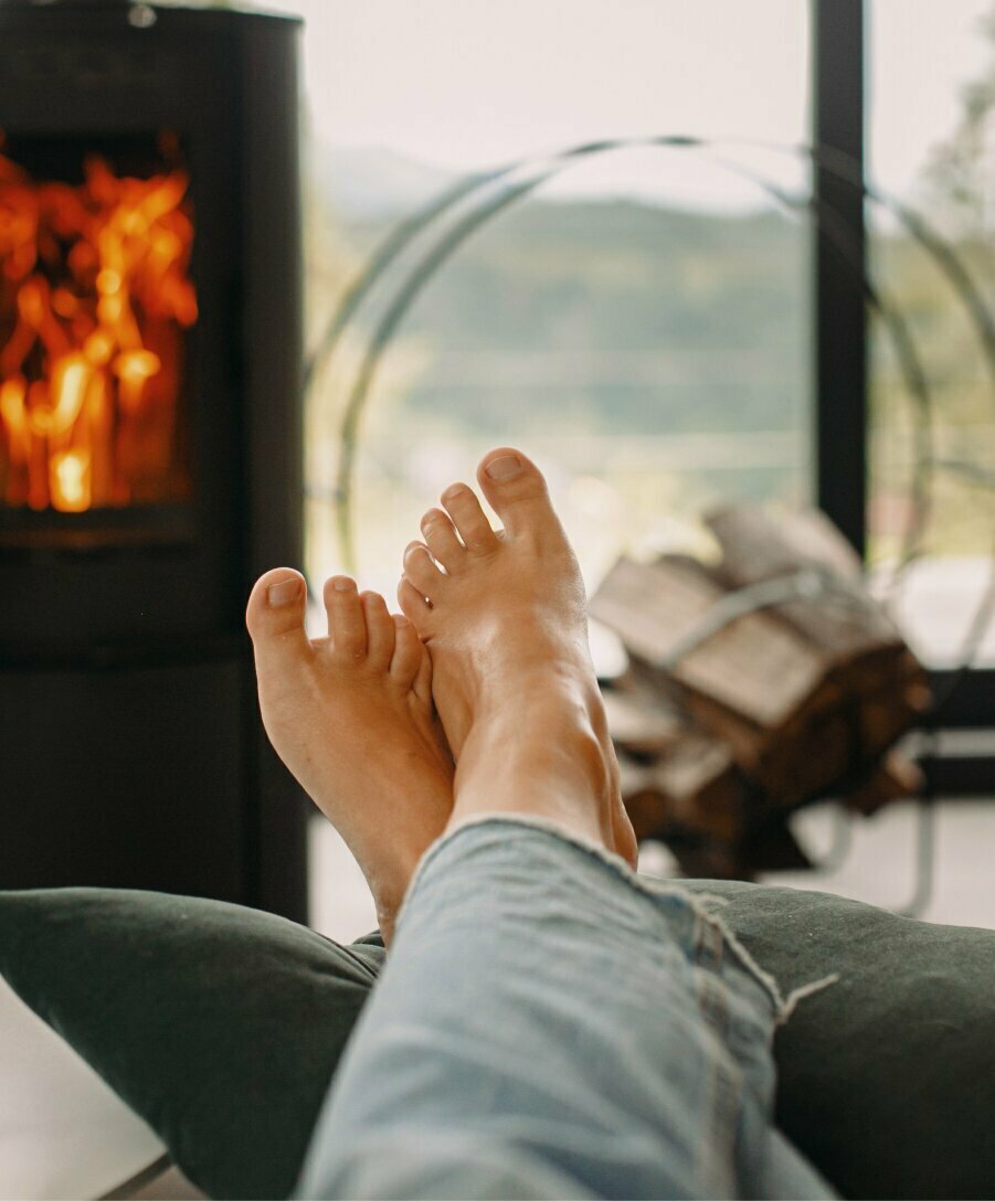 feet propped up in front of a fireplace